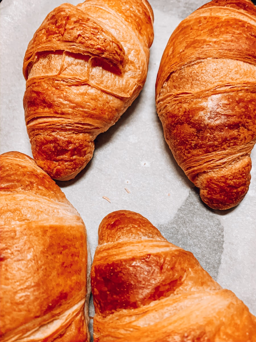 Deep-brown croissants cooling in a row on the bakery counter