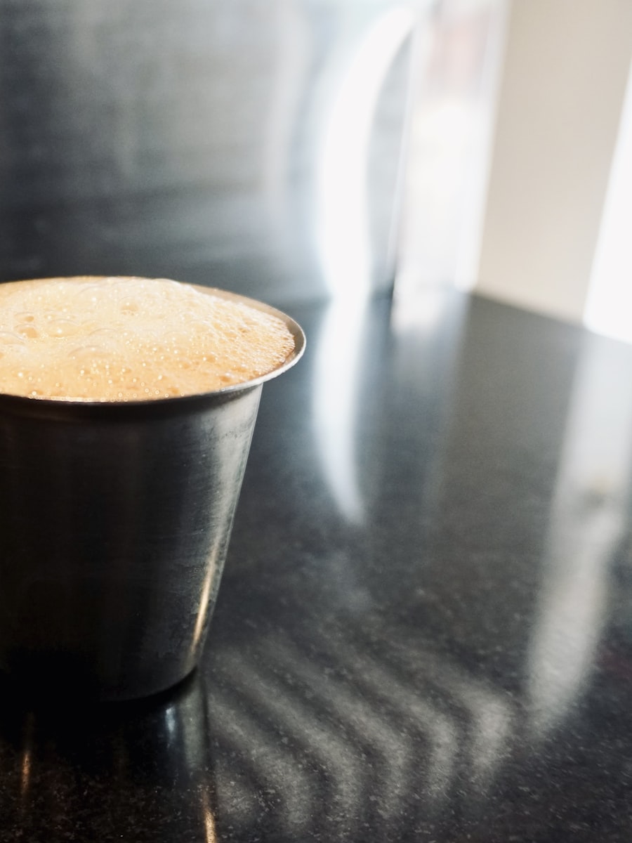 A steel tumbler of cold brew with a pale head of foam