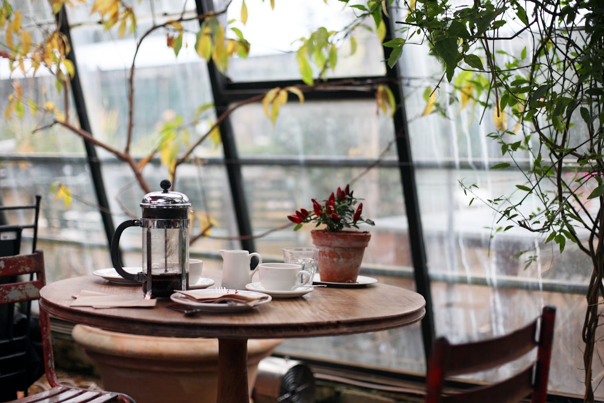 A small table for two in the bay window with morning light across it